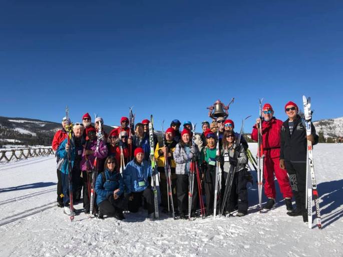 Team Texas with their guides taking their group photo out on the snow under bright blue skies