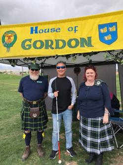 Michael standing in front of Gordon clan tent with two Scots from teh clan