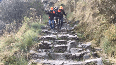 Michael being carried down the mountain on a sling by two Kandoo porters